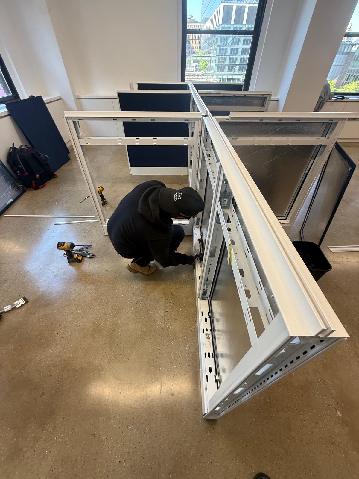 Installer assembling cubicle framework on site